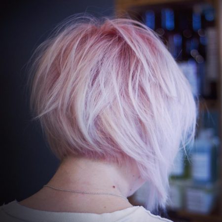 Back view of ladies layered short textured cut with pink colour by Stu Weller Hair